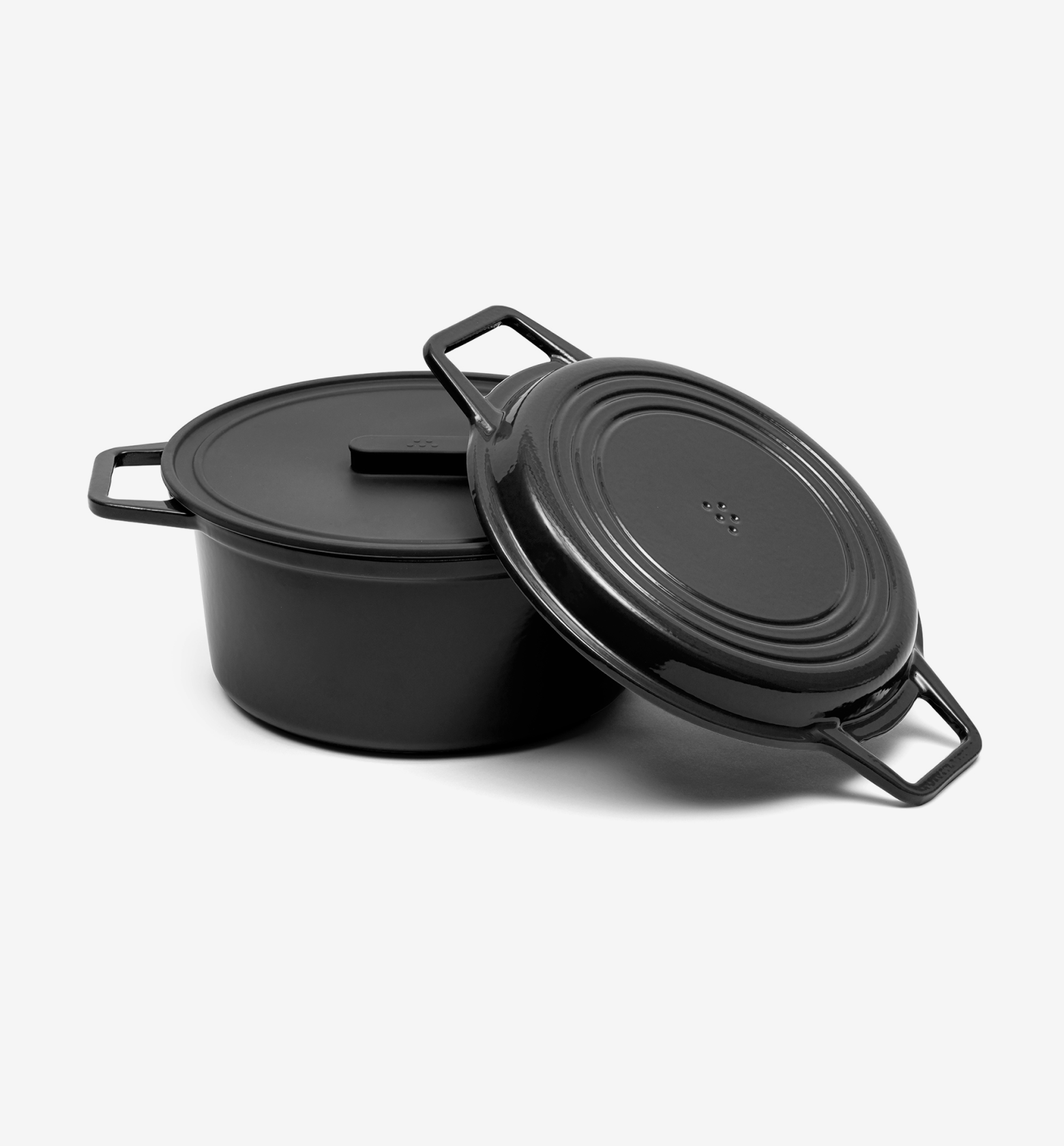 Black enameled cast iron Dutch oven with lid leaning against pot